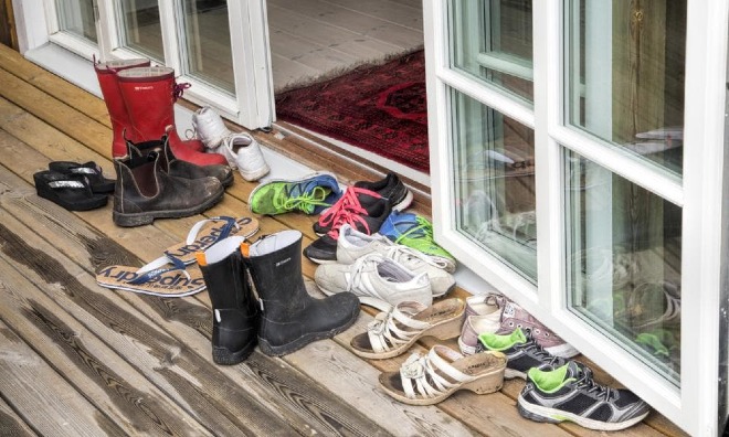Tháo giày trước khi vào nhà để tránh mang những vi khuẩn gây bệnh vào trong nhà. Ảnh: KP